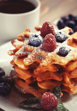 Waffle beyaz plaka ve kahve, çilek ile yakın çekim.