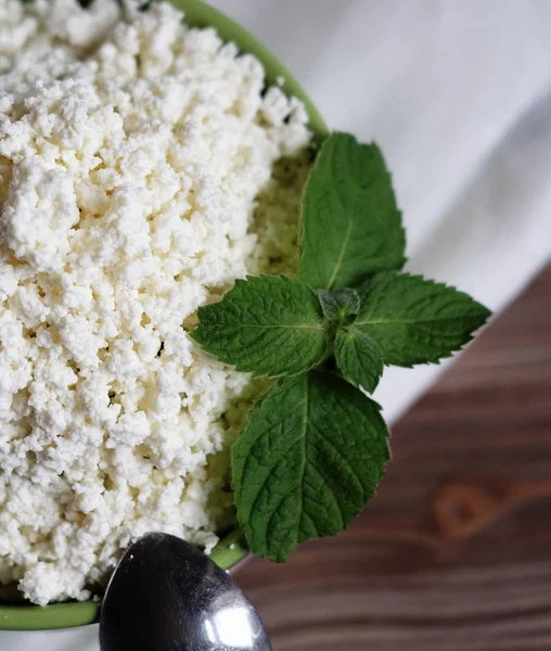 Fromage cottage à la menthe dans un bol vert sur une serviette blanche . — Photo
