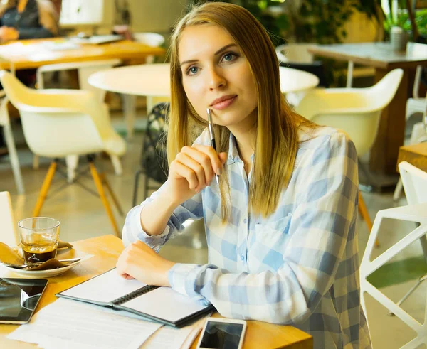 Розумна жінка записує свої ідеї і п'є каву в кафе — стокове фото