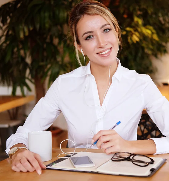 Primer plano de la joven hermosa mujer de negocios escribiendo en cuaderno — Foto de Stock