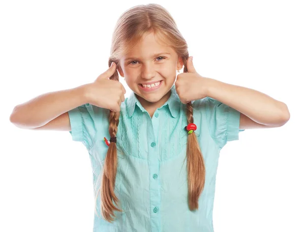 Lycklig liten flicka barn står isolerade över vit bakgrund. Ser kameran visar tummen. Livsstil och människor-konceptet. — Stockfoto