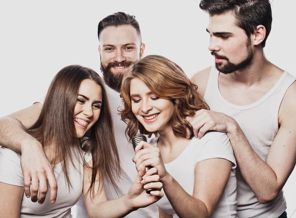 Retrato de meninas felizes e caras cantando em microfone sobre fundo branco . — Fotografia de Stock