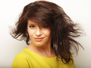 Yaşam tarzı ve insan konsepti: Beyaz arka planda sarı tişört giyen genç, tatlı, gülümseyen kıvırcık kız