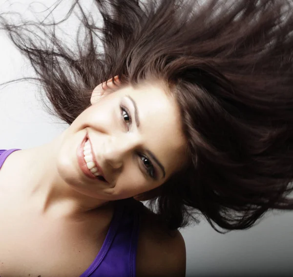 Junge Frau mit Haarbewegungen auf weißem Hintergrund — Stockfoto