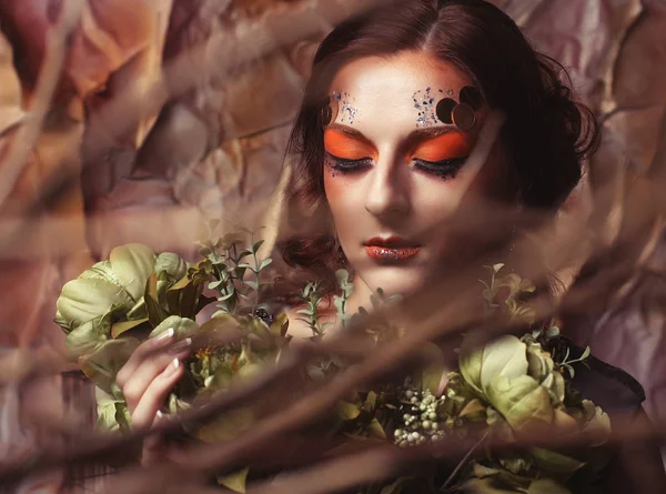 Закрыть портрет рыжеволосая женщина с ярким творческим макияжем держа сухие цветы — стоковое фото