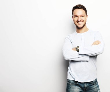 Mutlu gülümseyen adam beyaz arka planda kameraya bakıyor.