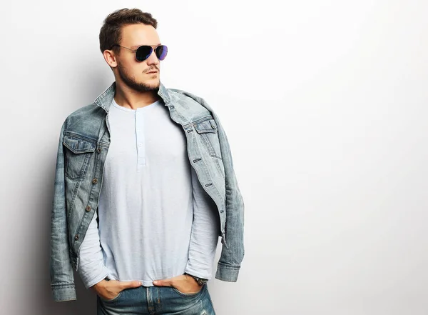 Young man in smart wear, wearing fashion sunglasses against white — Stock Photo, Image