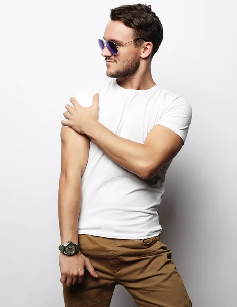 Joven en ropa inteligente, con gafas de sol de moda contra blanco — Foto de Stock