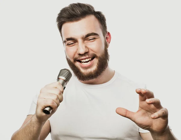 Životní styl a lidé koncept: mladý muž zpěv s mikrofonem — Stock fotografie