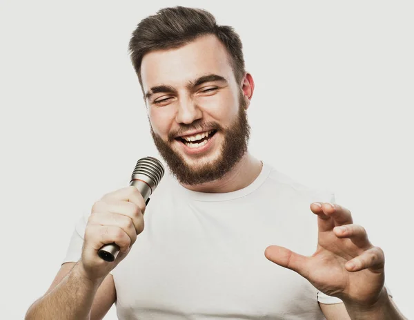 Lifestyle and people concept: young man singing with microphone — Stock Photo, Image