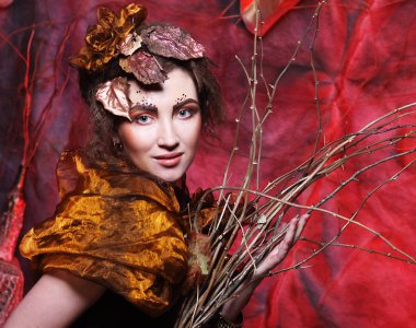 Güzellik ve sanat kavramı: kuru dalları ile parlak makyaj ile genç kadın