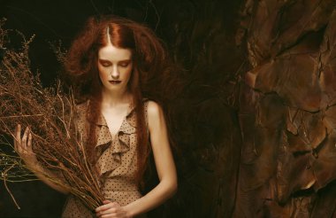 Güzellik ve sanat kavramı: kuru dalları ile parlak makyaj ile genç kadın