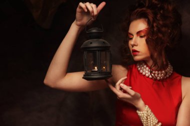 Şehvetli, güzel, esmer kadın kırmızı elbise içinde poz veriyor..