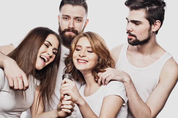 Grupo de amigos jugando karaoke sobre fondo blanco. Concepto sobre amistad y personas . — Foto de Stock