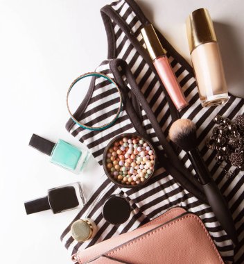 Gözlük, Vakfı, dudak parlatıcısı, toz, fırça, el çantası, çizgili gömlek üzerinde beyaz üstten görünüm izole ile stilize kadınsı flatlay.