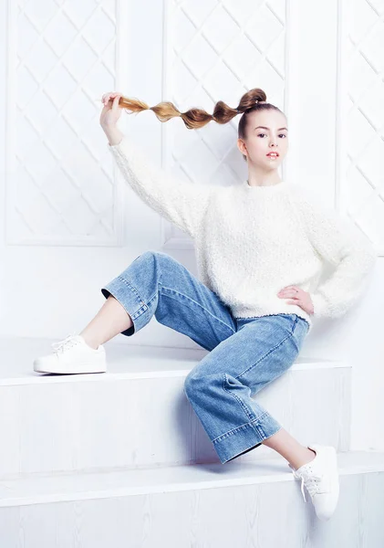 Fashion and people concept: stylish teen girl in casual clothes sitting on stairs and posing — Stock Photo, Image