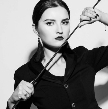 Siyah kıyafetli, güzel, baskın bir kadın.