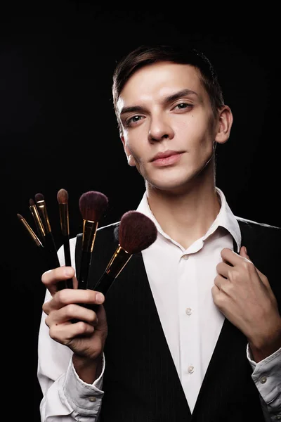 Young male make up artist posing with make-up brushes — Stock Photo, Image