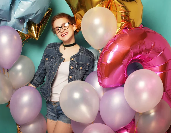 Счастливая рыжеволосая девушка ждет вечеринки. Великолепная веселая молодая женщина веселится с блестящими воздушными шарами, на голубом фоне. Концепция образа жизни . — стоковое фото