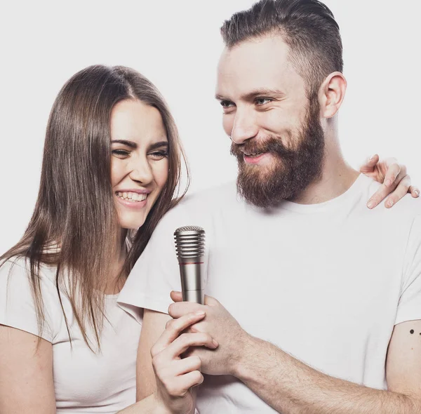 Lyckligt par sjunga i karaoke över vit bakgrund, — Stockfoto