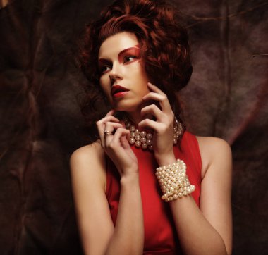 Şehvetli, güzel, esmer kadın kırmızı elbise içinde poz veriyor..