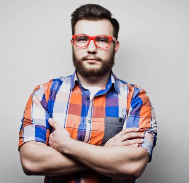 Yaşam tarzı ve insan konsepti: Genç sakallı adam beyaz arka planda kollarını kavuşturuyor