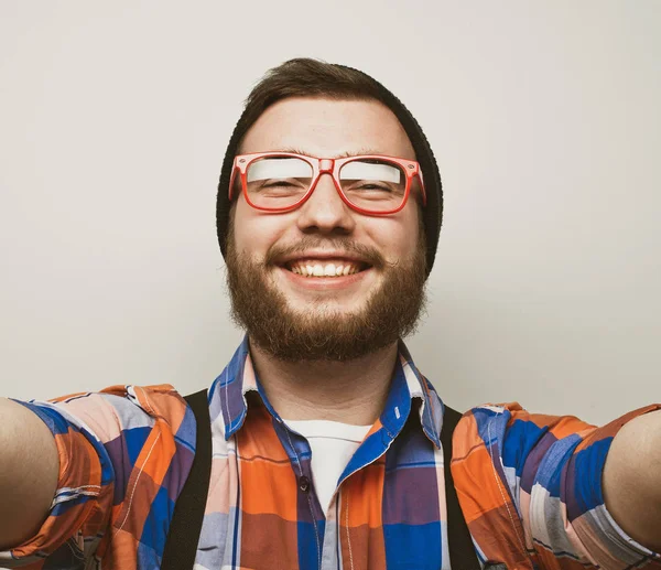 Close up portrait of a cheerful bearded man taking selfie over white background — Stock Photo, Image