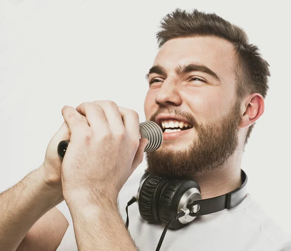 Νέοι γενειοφόρος άνδρας με ακουστικά και μικρόφωνο πάνω από το λευκό φόντο — Φωτογραφία Αρχείου