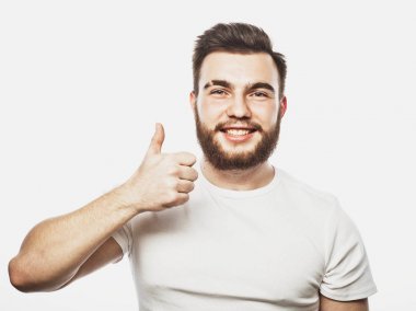 Beyaz arka planda izole edilmiş iyi bir hareket gösteren neşeli, sakallı genç bir adamın portresi.