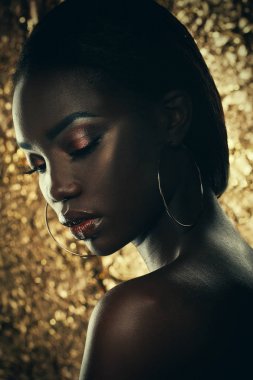 Moda studio bir olağanüstü güzel Afro-Amerikan model altın arka plan üzerinde kapalı gözlerle portresi