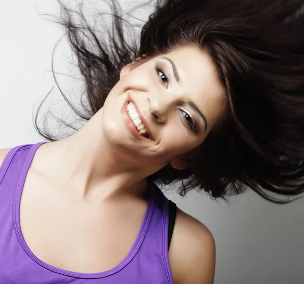 Jeune femme avec le mouvement des cheveux sur fond blanc — Photo