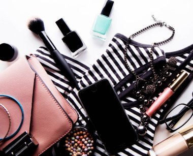 Düz pembe deri kadın çanta aksesuarları kozmetik ile yatıyordu. 