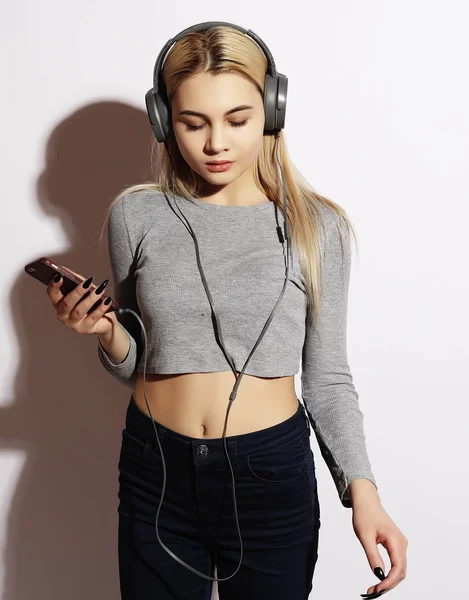 Style de vie et concept de personnes : Belle jeune femme à l'écoute de la musique dans les écouteurs — Photo