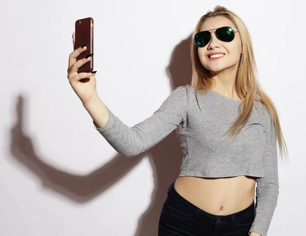 Kadın beyaz bir arka plan üzerinde izole smartphone selfie fotoğraf yapma — Stok fotoğraf