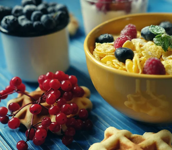 Pequeno-almoço saudável. Flocos de milho com framboesas e mirtilos, granola com iogurte e bagas, bolachas e leite. Um grande começo de dia. Vista superior . — Fotografia de Stock