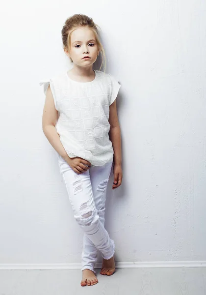 Moda infantile. Bella ragazza bionda seria pensierosa in vestiti bianchi. Moda e concetto di persone. — Foto Stock