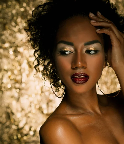 Jovem mulher americana africana elegante com cabelo afro. Maquiagem de glamour. Fundo dourado . — Fotografia de Stock