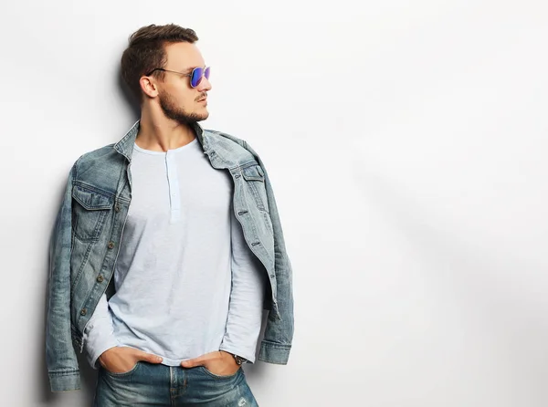 Young man in smart wear, wearing fashion sunglasses against white background — Stock Photo, Image