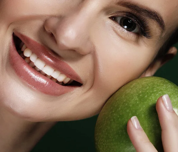 Foto de la cabeza de la mujer sosteniendo manzana verde sobre fondo verde — Foto de Stock