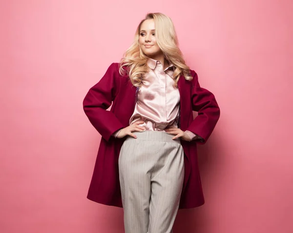 ピンクを背景に流行の服で写真のための美しいモデルポーズ — ストック写真