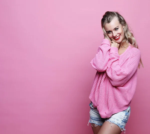 Lifestyle, beauty and people concept: Young smiling blond girl over pink background — Stock Photo, Image