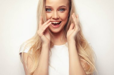 Yaşam tarzı ve insan konsepti. Güzel bir kız sana şaşırmış ve şok olmuş görünüyor. Ürününüzü sunuyorum. Etkileyici yüz ifadeleri. Stüdyo çekimi.