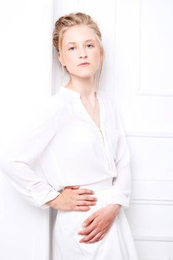 Güzel dalgın ciddi sarışın kız Beyaz giysili. Moda ve insanlar kavramı.