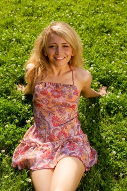 Dışarıda oturan kadın gülümsüyor. 