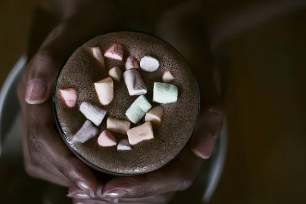 hands of an African girl holding cocoa with a marshmallow