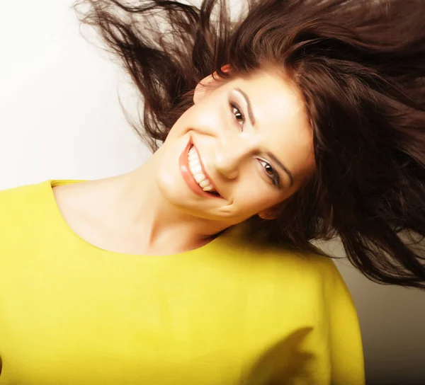 Lifestyle and people concept: Young cute smiling curly girl wearing yellow t-shirt over white background — Stock Photo, Image