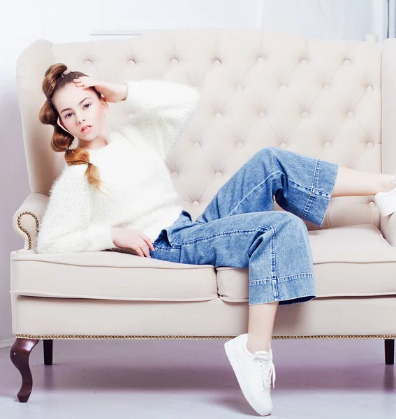 穿着休闲装的时髦少女坐在沙发上摆姿势 — 图库照片