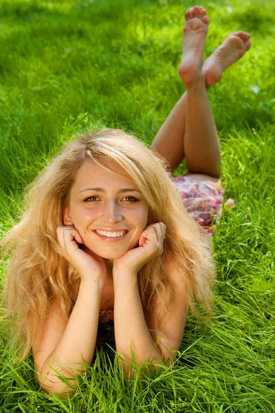 Mladá usměvavá žena na trávě — Stock fotografie