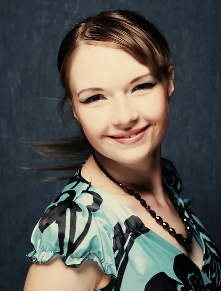 Woman in a blue dress posing on a blue background — Stock Photo, Image