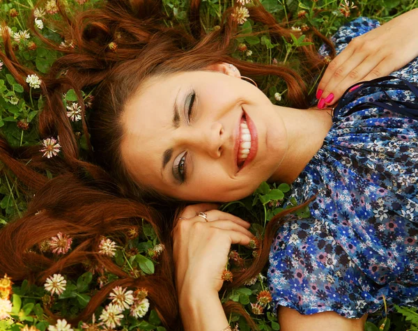 Joven hermosa chica se acuesta en una hierba — Foto de Stock